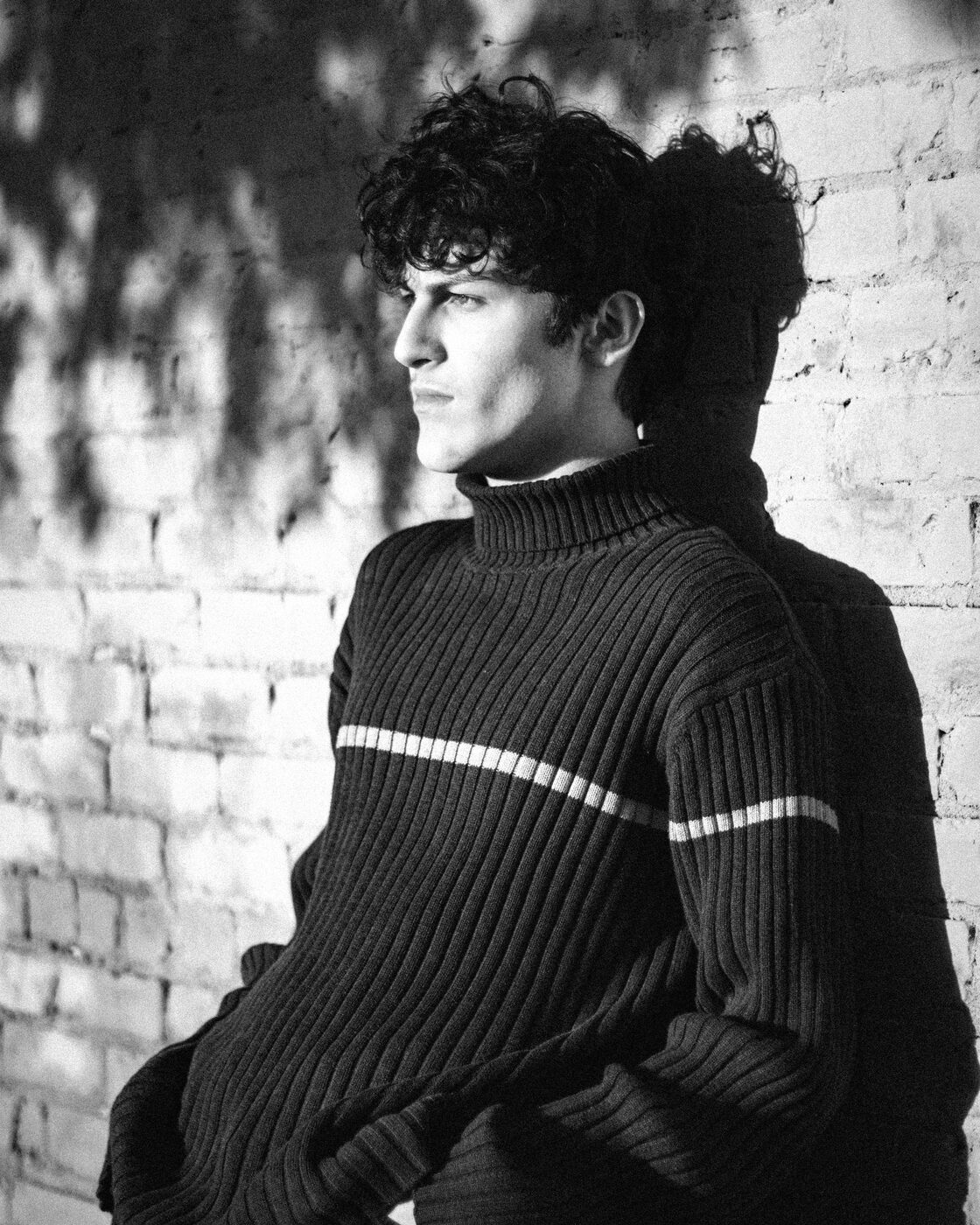 Portrait of Isaac Reese against a brick wall